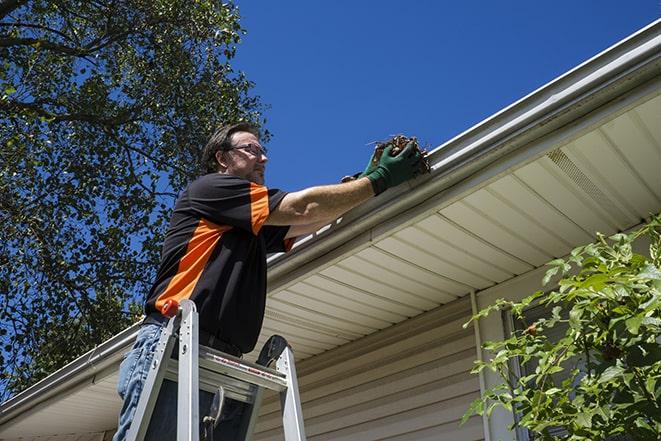 worker fixing a broken gutter on a house in Armagh, PA